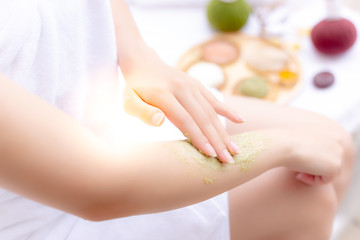 Obraz na płótnie Canvas Charming beautiful woman use herbal scrubs for scrubbing the old skin cells at her beautiful arm that makes better nice skin and skin rejuvenation. Gorgeous girl scrub skin by herself at luxury hotel
