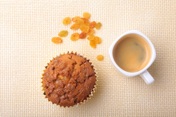 Perfect morning breakfast with Delicious homemade cupcakes with raisins, chocolate chips and espresso coffee in white cup on textile background. Muffins.