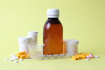 set of different medicines for the treatment of colds on a colored background. thermometer,...