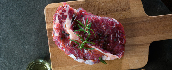 Fresh raw Prime Black Angus beef steaks on wooden board: