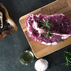 Fresh raw Prime Black Angus beef steaks on wooden board: