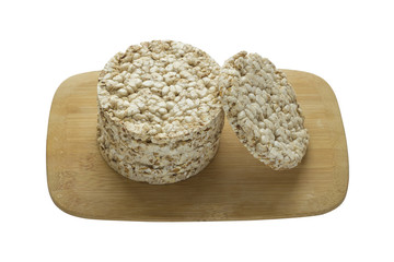 Stack of round rice crispbreads on wooden board isolated on white background. Concept of healthy diet for your design.