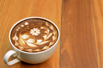 Hot coffee mocha decorated on wooden background, latte art.