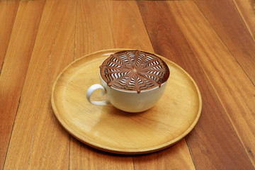 Hot coffee mocha decorated on wooden background, latte art.