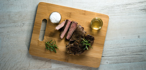 Grilled steak sliced on a cutting board. 
