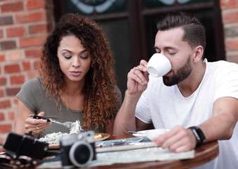 Young couple enjoying coffee at a street cafe and  laughing