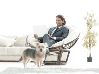 modern businessman with laptop sitting in living room.