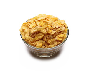 Crunchy corn flakes, cereal, muesli pile in glass bowl isolated on white background