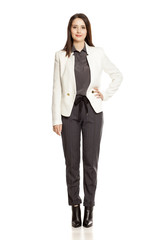 Young businesswoman  in pants and suit standing on white background
