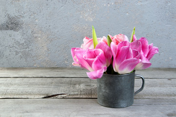 Pink tulips in vintage metal cup