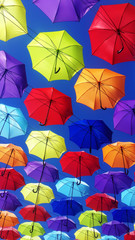 Fototapeta na wymiar multicolored umbrellas flying in sky 