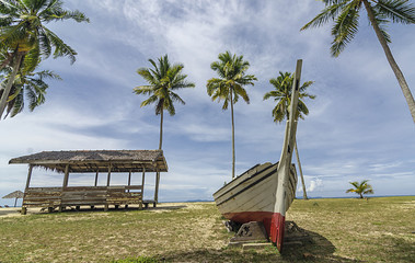 Replica of red and white boat stranded near the beach during daylight