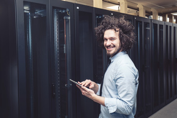 male technician inspecting and working on servers in server room