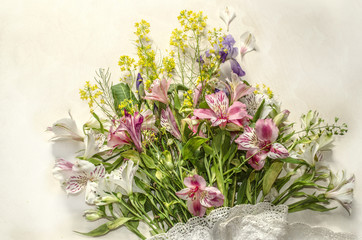 Delicate background of wild herbs with white and pink flowers of Alstroemeria and purple iris with openwork border on light plywood
