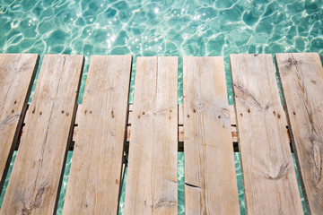 Background of wooden deck and blue water see. Mallorca, Spain. Top view. 