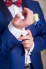 the groom is dressed in a blue suit and zap up on a white shirt