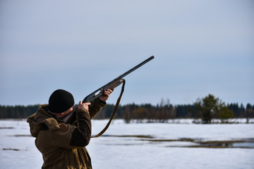 The hunter is aiming for a shot at flying game, on a spring hunt