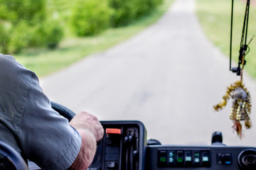 Driver of  bus manages  vehicle, carrying people along  tourist route_