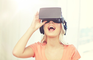technology, virtual reality, cyberspace, entertainment and people concept - happy amazed young woman in virtual reality headset or 3d glasses and headphones at home