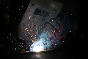 professional welding worker and sparks
