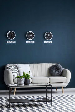 Time zones clocks above sofa
