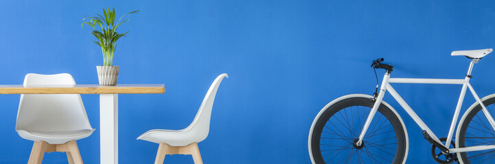 Fototapeta na wymiar White bike by blue wall