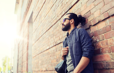 Obraz premium travel, tourism, lifestyle and people concept - man with backpack standing at city street wall