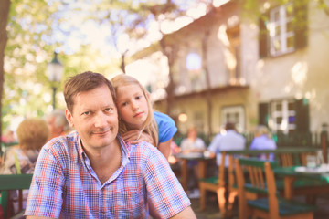 Father and daughter enjyoing sunny afternoon at Austrian Heuriger - typcial wine tavern