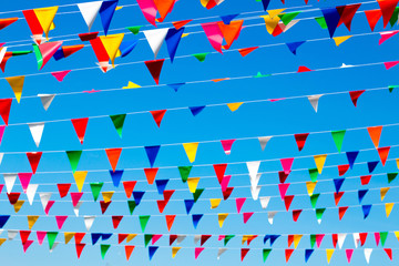 Multi color triangular flags with clear blue sky, outdoor celebration party