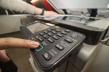 Man pushing copy button to copying paper from Photocopier