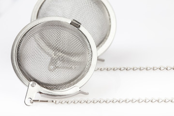 Two tea mesh on a chain on a white background.
