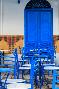 Blue chairs and tables arranged next to a blue door