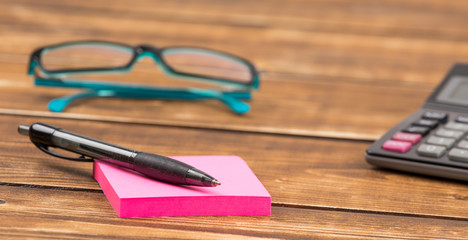 business workplace with glasses, calculator and pen