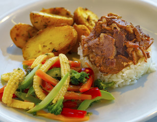 Turkish-style beef ribs served with rice, potatoes and garnish
