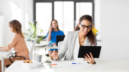 business, technology and people concept - african american businesswoman with tablet pc computer working at office