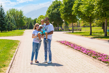 Obraz premium African American happy family: black father, mom and baby boy on nature. Use it for a child, parenting or love concept