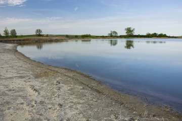 The sandy shore of a quiet lake