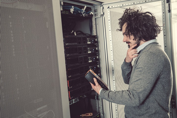 Fototapeta na wymiar male technician inspecting and working on servers in server room