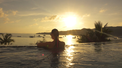 Fototapeta premium CLOSE UP: Lovely woman looks at the breathtaking tropical seaside at sunset.