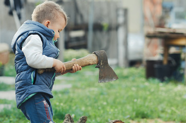 a little kid is chopping a tree, a big axe is dangerous