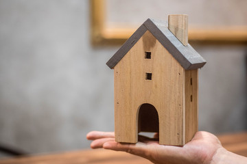 Obraz na płótnie Canvas hand holding small house. Home insurance concept.
