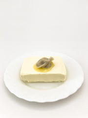 Pelmen in oil on a white plate on a white background