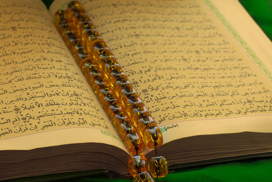 Holy islamic book Koran on the draped table with a rosary. Ramadan Kareem beautiful poster, banner, postcard for the celebration of the festival of the Muslim community