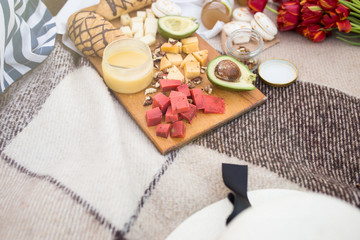 Food on a picnic is on a plaid. Avocado croissant and cheese with honey closeup