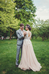 Couple in wedding attire with against the backdrop of the park, the bride and groom