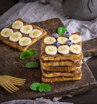 pile of square fried bread slices with chocolate and banana