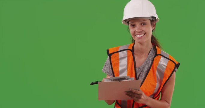 Joyful construction worker taking notes smiling for green chroma key compositing