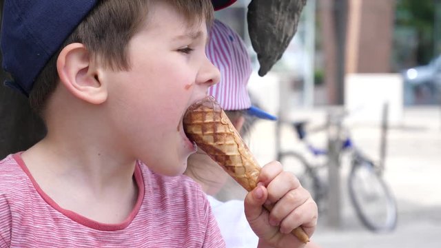 Little boy and girl children funny licking eating ice cream on a street public place