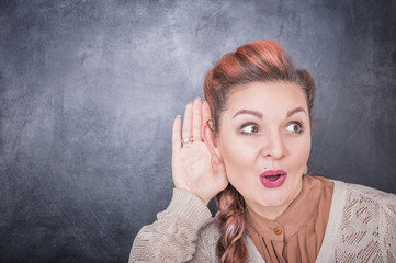 Funny woman eavesdrop on blackboard background