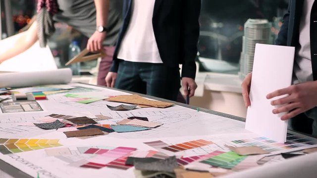 Designers at Work. A group of young designers led by the head are working on the project of design business center, private home, studio, shop, office.